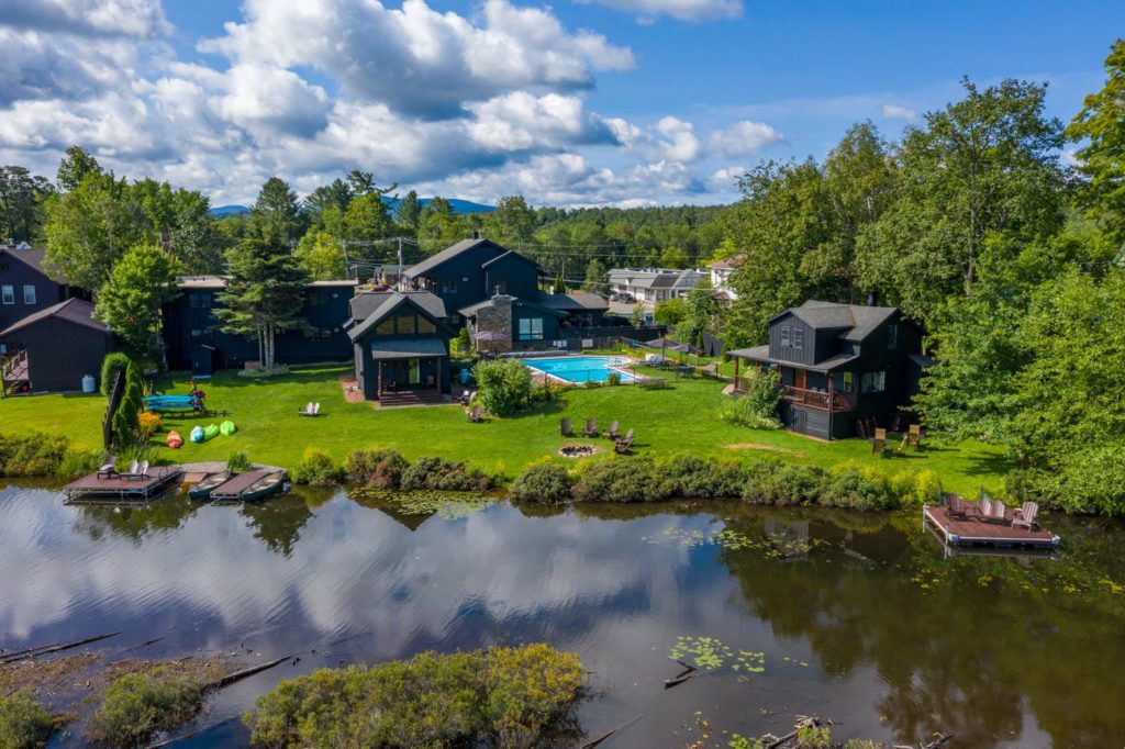 An aerial view of a house with a pond in the background.