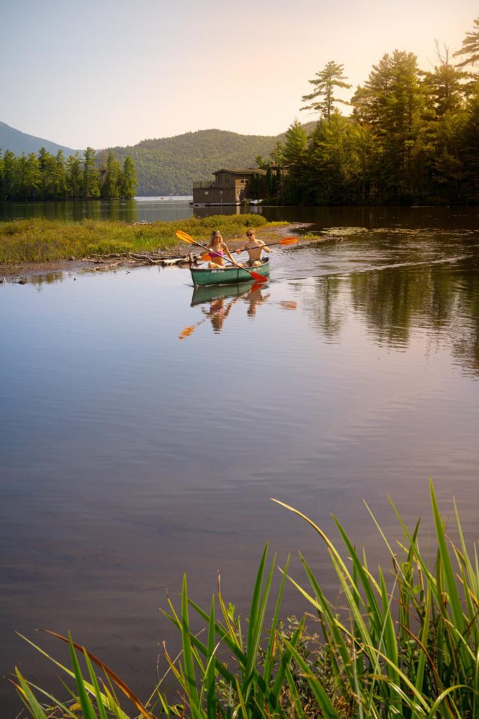 Two people paddling a canoe on a lake.