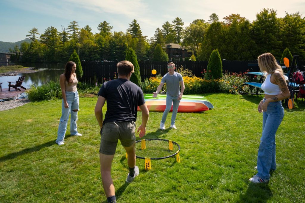 A group of people playing a game of frisbee on a lawn.