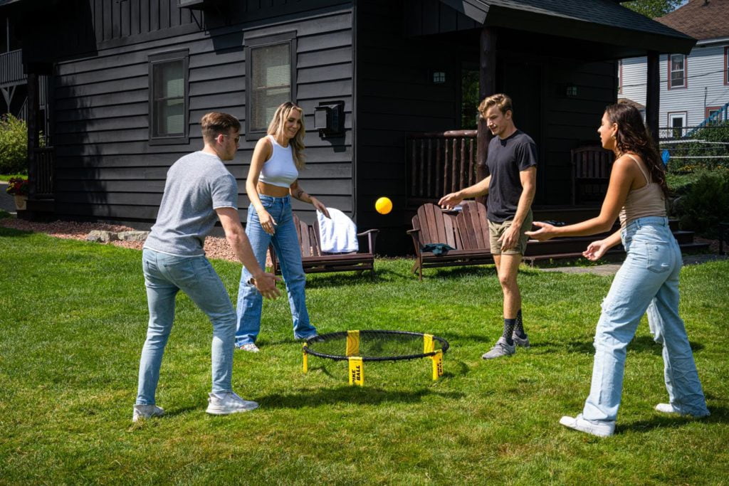 A group of people playing with a trampoline in the yard.