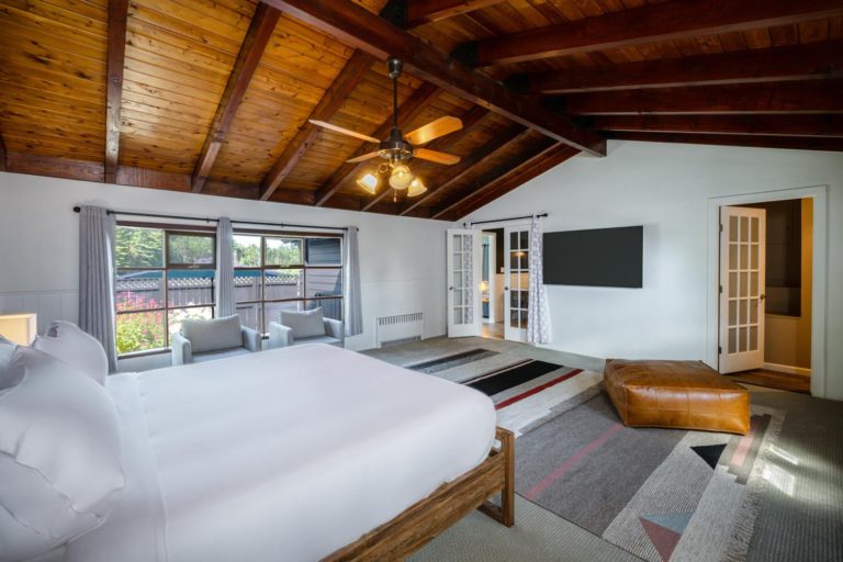 A bedroom with wooden ceilings and a bed.