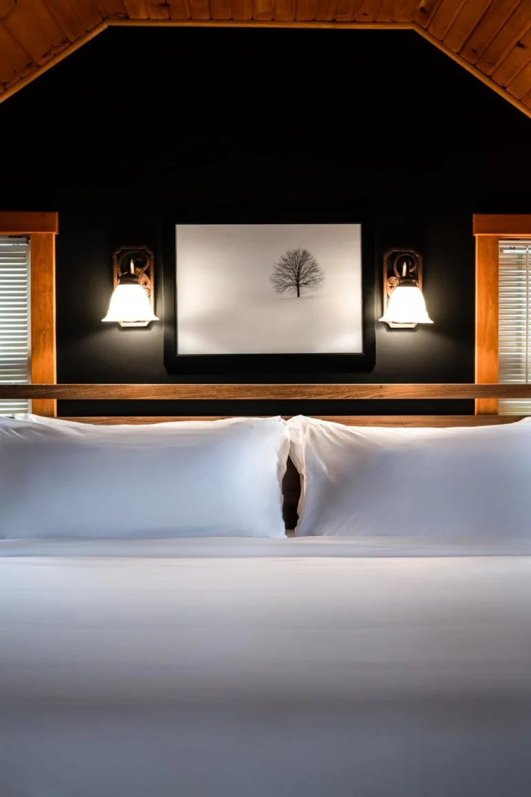 A bed with white sheets and a wooden headboard.