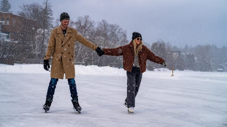 A couple skating on a frozen lake.